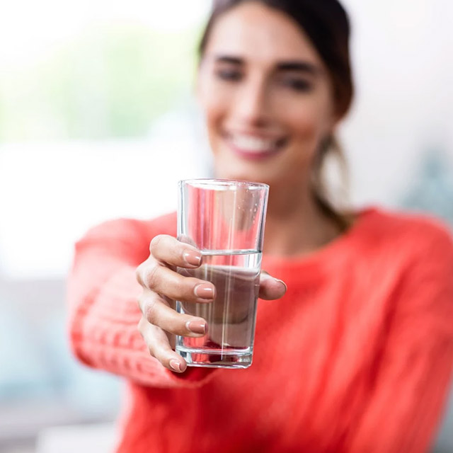 woman holding glass of water